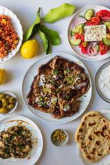 Greek food, lamb chops with couscous, feta salad, hummus and flat breads