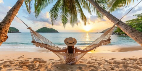 Happy woman relaxing in a hammock on a tropical beach at sunset