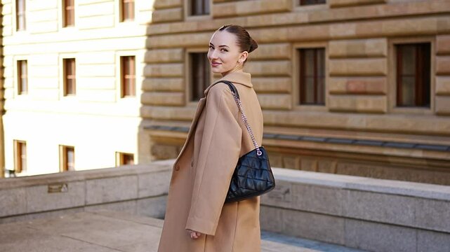 Young beautiful woman wearing coat walking in the city centre of Prague, Europe