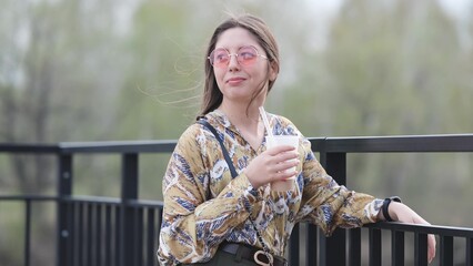Pensive happy woman sipping a milkshake in the street