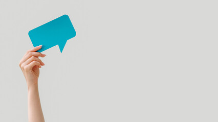 Speech bubble. Blank message. Online chat. Female hand holding blue dialogue icon mockup for text...