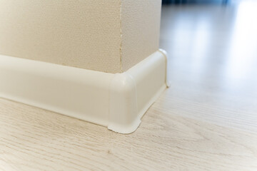 This image showcases an upclose view of a pristine white skirting board placed elegantly against a...