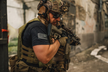 Fototapeta premium Close up of brave soldier with rifle in a mission on a battlefield.