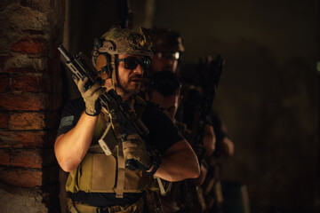Group of air soft fighters in dark building in ambush ready for action
