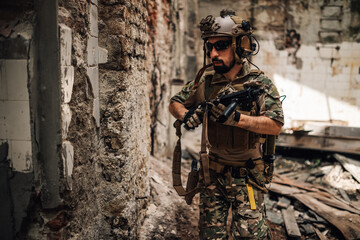 Fototapeta premium Solider with rifle attacking opponent territory in rescue operation.