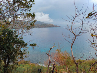 A view of beach and mountains from a hill
