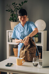 Asian nurse completing tasks efficiently with packed backpack