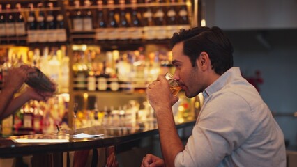 Profile closeup of smiling smart man in white shirt drinking cocktail in Old fashioned of special party beverage vibrant at nightclub on Friday meeting night time at luxurious counter bar. Vinosity.