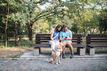 Couple relaxing on the bench with their dogs