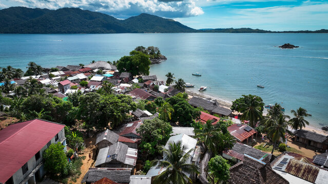 Aerial view of Nosy Komba Island in Madagascar showcasing its vibrant village and lush tropical surroundings under clear skies