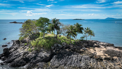 Aerial view of Nosy Komba Island in Madagascar displaying lush vegetation and rocky coastline under a bright sky