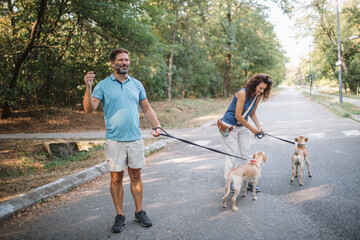 Couple walking with their dogs in the park