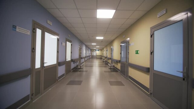 Empty well-lit corridor of hospital leads past offices of specialized doctors. Freshly renovated hospital ready to attend patients