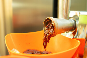 meat grinder filled with beef liver symbolizes the raw and unrefined nature of food preparation....