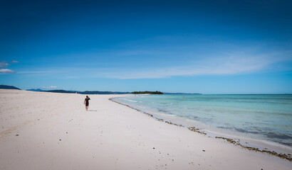 A serene stroll along the pristine shores of Nosy Iranja Island in Madagascar under a bright blue sky