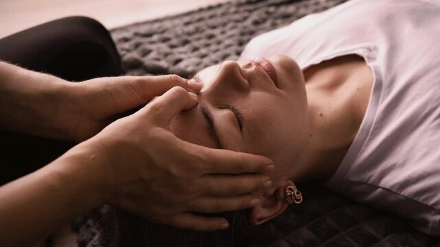 Therapist woman doing a Shiatsu massage to young woman patient. Holistic therapy, treatment with manipulations. Wellness and alternative medicine