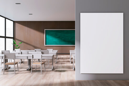 Modern stylish classroom interior with empty white mock up banner, panoramic window and city view, wooden floor and green blackboard on wall. School, university and education concept. 3D Rendering.