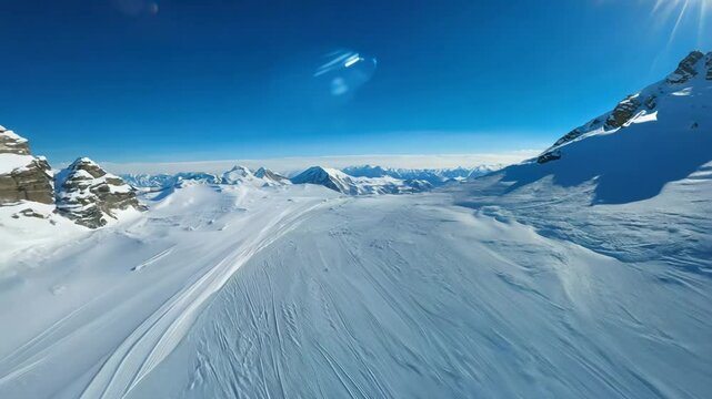 Fly-through, high speed video video over a snow-covered mountain range with back light.