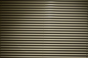 Fototapeta premium White blinds in the yellow light in the evening