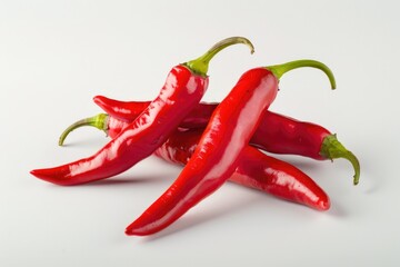 A collection of bright red hot peppers arranged on a clean white surface, perfect for use in still life photography or as a prop in cooking and food-related images