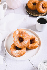 Sweet sugar donuts on a white plate on the table vertical view