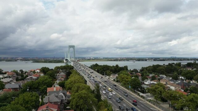 A scenic view of the Whitestone Bridge crossing the East River, connecting urban and natural landscapes. The nearby park offers green spaces with river views,