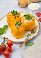 Stuffed yellow pepper. Sweet pepper with rice and minced meat on a light background.