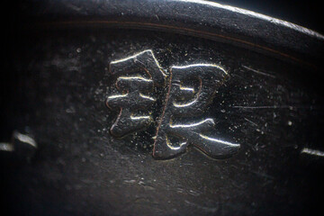Chinese characters engraved on a Chinese coin in close-up	
