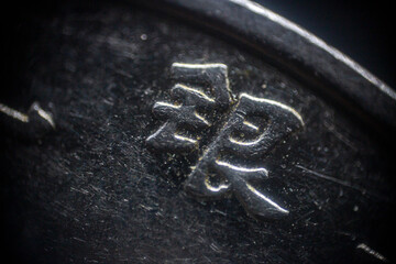 Fototapeta premium Chinese characters engraved on a coin in close-up 