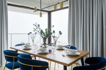 Modern dining room with blue chairs and city view