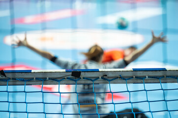 Detail of handball goal crossbar with net penalty shot in the background.