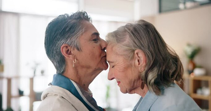 Mature women, love and forehead kiss in home for care, support and trust in relationship. Senior lesbian couple, romantic gesture and affection in living room for security, wellness and commitment