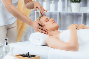 Obraz premium Caucasian woman enjoying relaxing anti-stress head massage and pampering facial beauty skin recreation leisure in dayspa modern light ambient at luxury resort or hotel spa salon. Quiescent