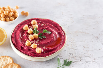 Beetroot hummus with parsley and olive oil in a plate on a gray background, top view. Arabic, Turkish cuisine.