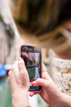 woman taking a picture of canal in Venice, italy
