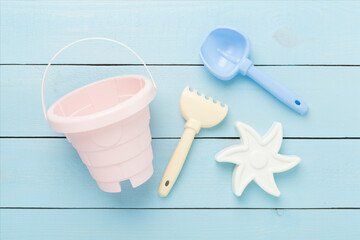 Cute toys for playing with sand on wooden background, top view