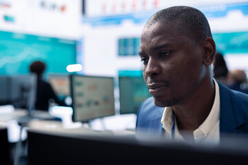 Skilled general manager examining company numbers to calculate profit in order to invest in business expansion. Analyst reviewing firm productivity and efficiency to achieve goals.