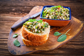 Traditioneller italienischer Toskana Aufstrich mit Steinpilzen und Frühlingszwiebel fein gehackt auf frischen knusprigen Baguette Scheiben und in einer Schale serviert als Nahaufnahme
