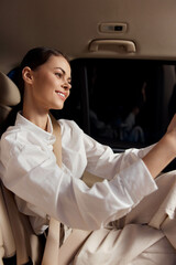 car driver a woman is seated behind the steering wheel, her hand resting on it, as she gazes directly at the camera, conveying confidence and readiness