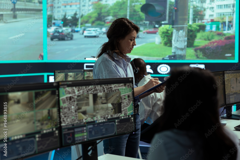 Poster supervisor gathering intelligence from radar based surveillance footage, team of operators analyzing