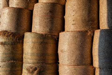 des bottes de foins entassées dans une grange