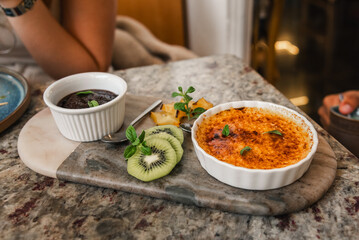 Crème Brûlée and Chocolate Mousse with Fresh Kiwi on a Marble Plate