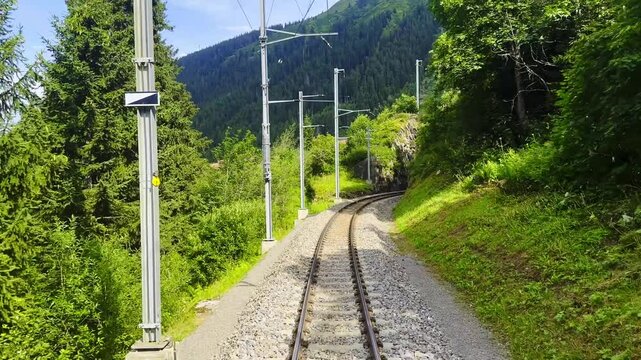 Front View on Glacier Express Train on Railroad Tracks and Mountainscape and Valley in a Sunny Summer Day in Sedrun, Surselva, Oberalp, Grisons, Switzerland, Europe