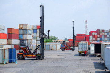 Container forklift loading at port onto truck with pile of colorful containers, background and copy...