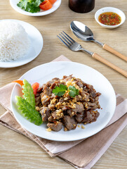 Stir-fried pork with garlic and pepper on a wooden table