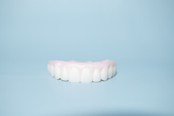 Implant-supported hybrid prosthesis on blue background