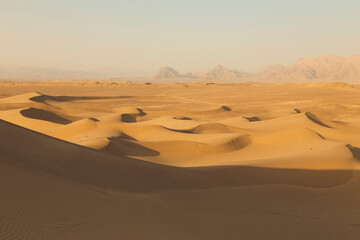 Golden-looking dunes in the heart of Iranian desert at sunset around Yazd, Iran.