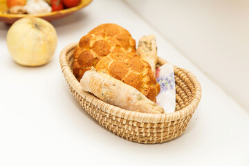 Basket with assorted bread loaves on white table, freshly baked, traditional bakery products, wheat and rye breads in woven basket, bread concept