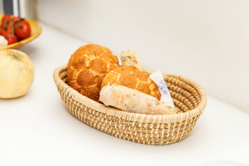 Basket with fresh bakery bread, crispy loaves, baguette on white surface, homemade concept