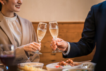 居酒屋で忘年会・新年会・飲み会・宴会をする仕事仲間・同僚・上司部下の男女
